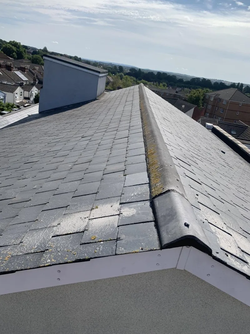 Slate roof with newly bedded ridge tiles overlooking rooftops