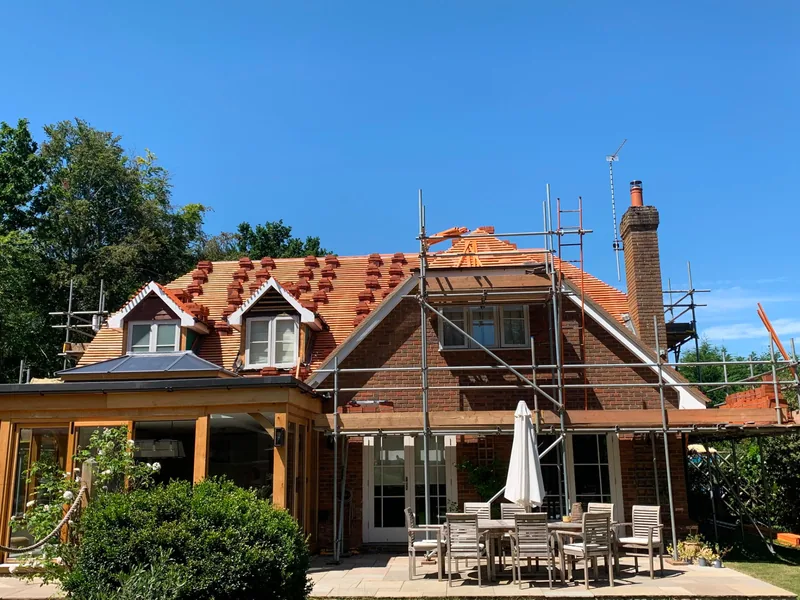 Newly tiled red clay roof mid-installation